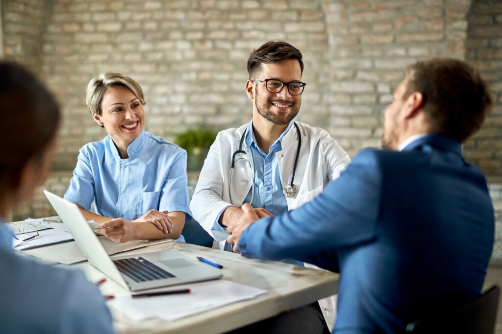 Group of healthcare workers greeting a financial advisor during the meeting